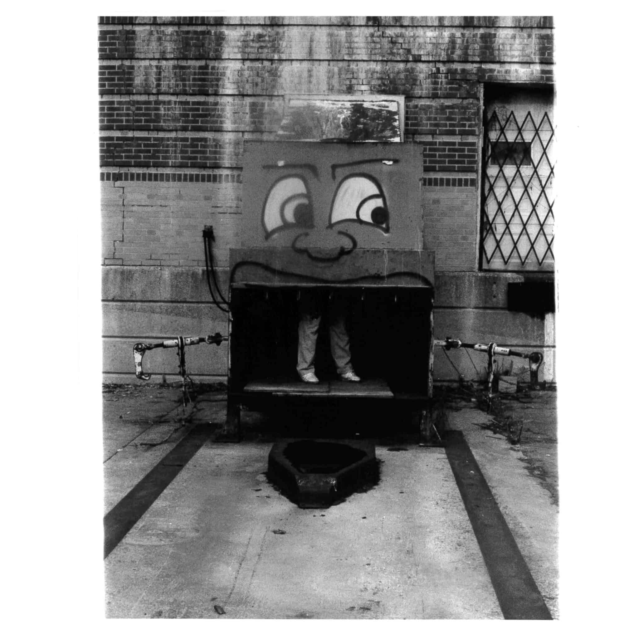 Photo of a box with eyes painted on it and a little girl's legs visible at the bottom.