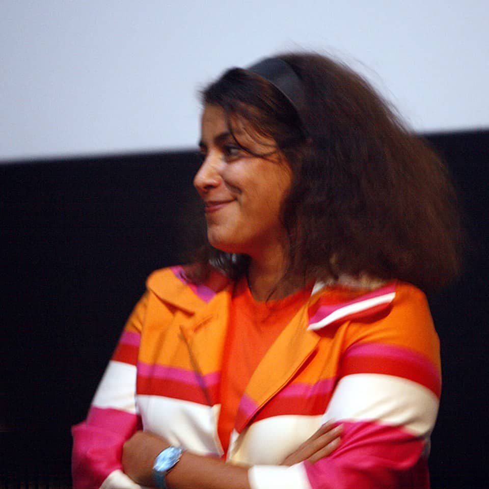 Marjane Satrapi looking to the side and smiling.